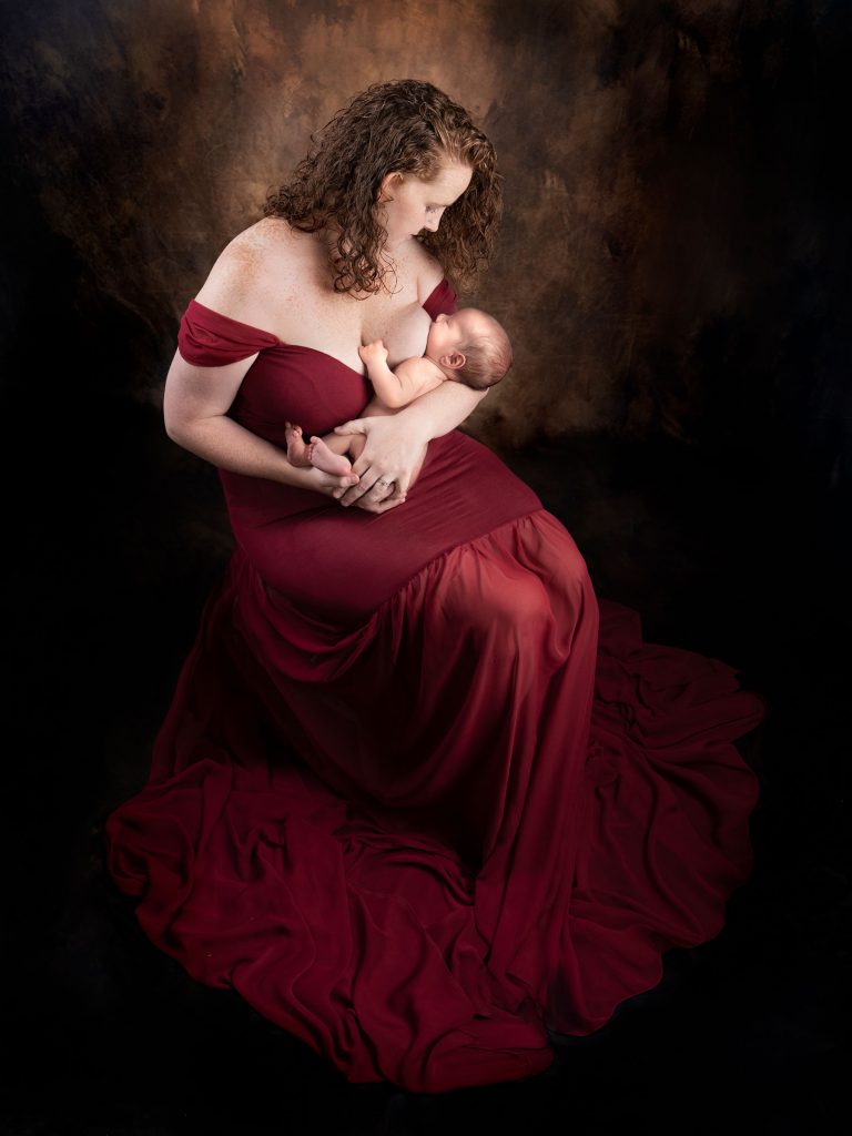 Mother breast feeding and newborn captured by Treasured Moments Photography