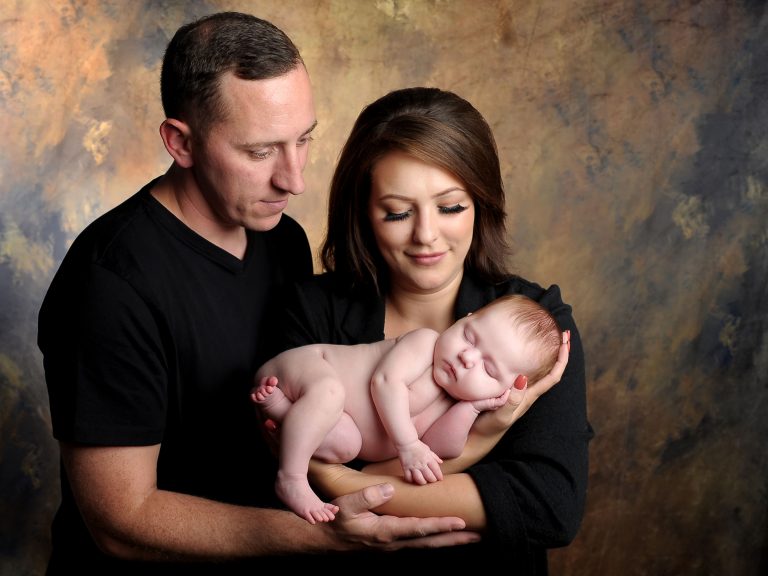 Family portrait with newborn baby captured by Treasured Moments Photography